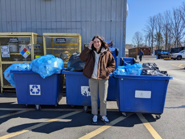 Colleen-Regan-Zero-Waste-Specialist-Standing-in-Front-of-1555-Pieces-of-Single-Use-Plastics-Weighing-58-lbs-and-4-Ounces